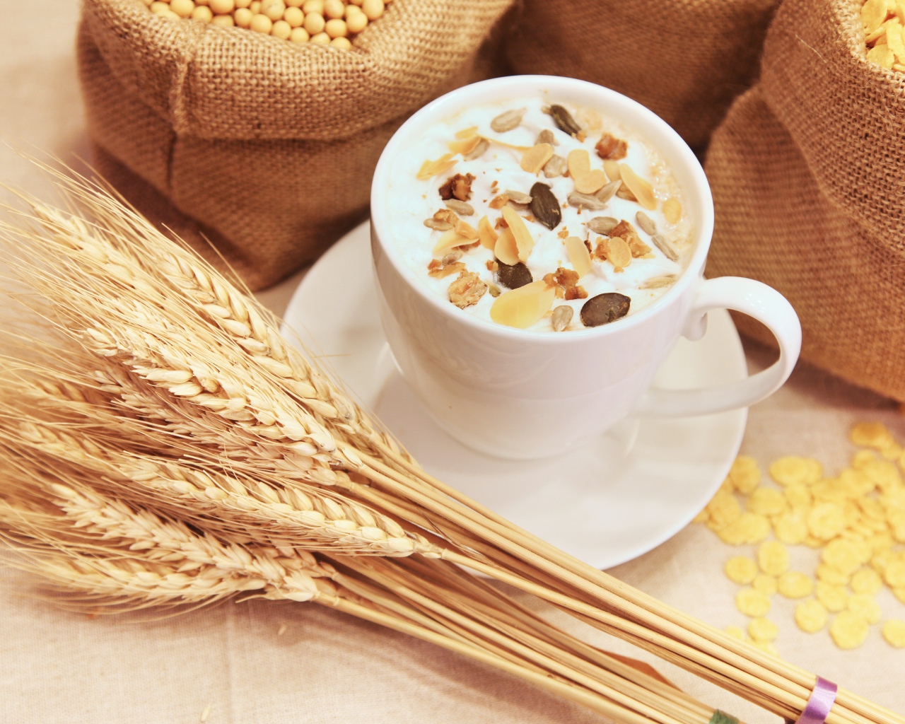 Чашка молока с мюсли на столе с колосками