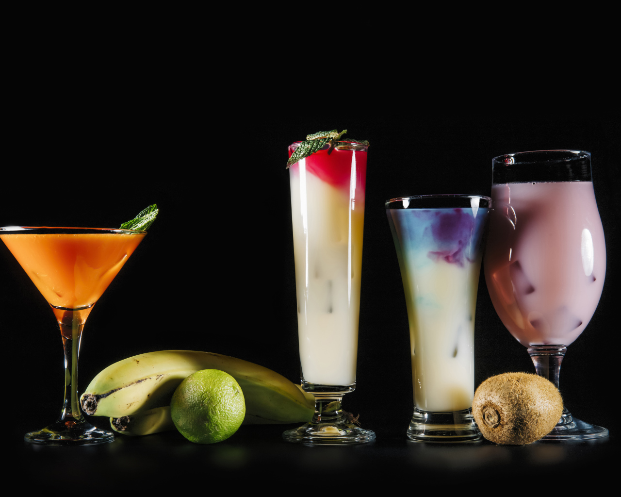 Вкусные тропические коктейли на черном фоне с фруктами