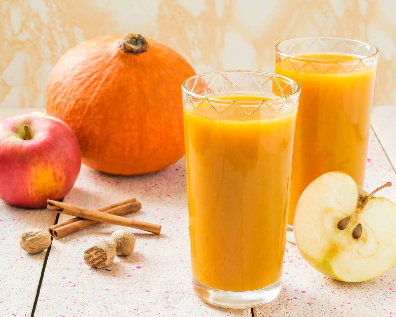 Свежевыжатый сок в стаканах на столе с фруктами