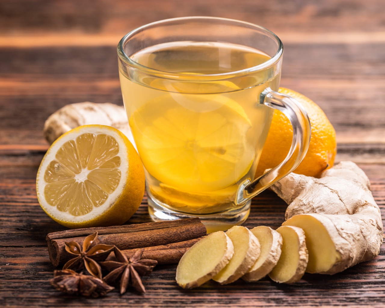 Стеклянная чашка чая на столе с лимоном, имбирем и специями