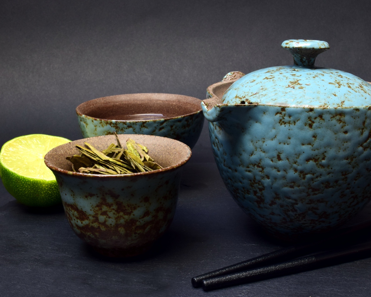 Зеленый чай на столе с посудой и лаймом