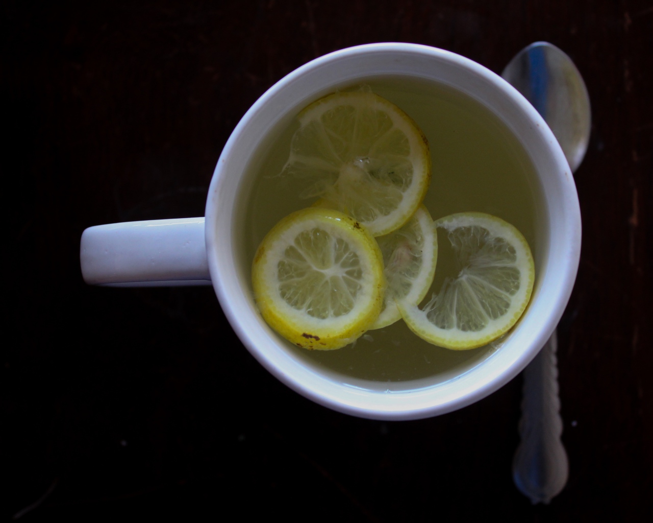 Зеленый чай с лимоном на черном фоне