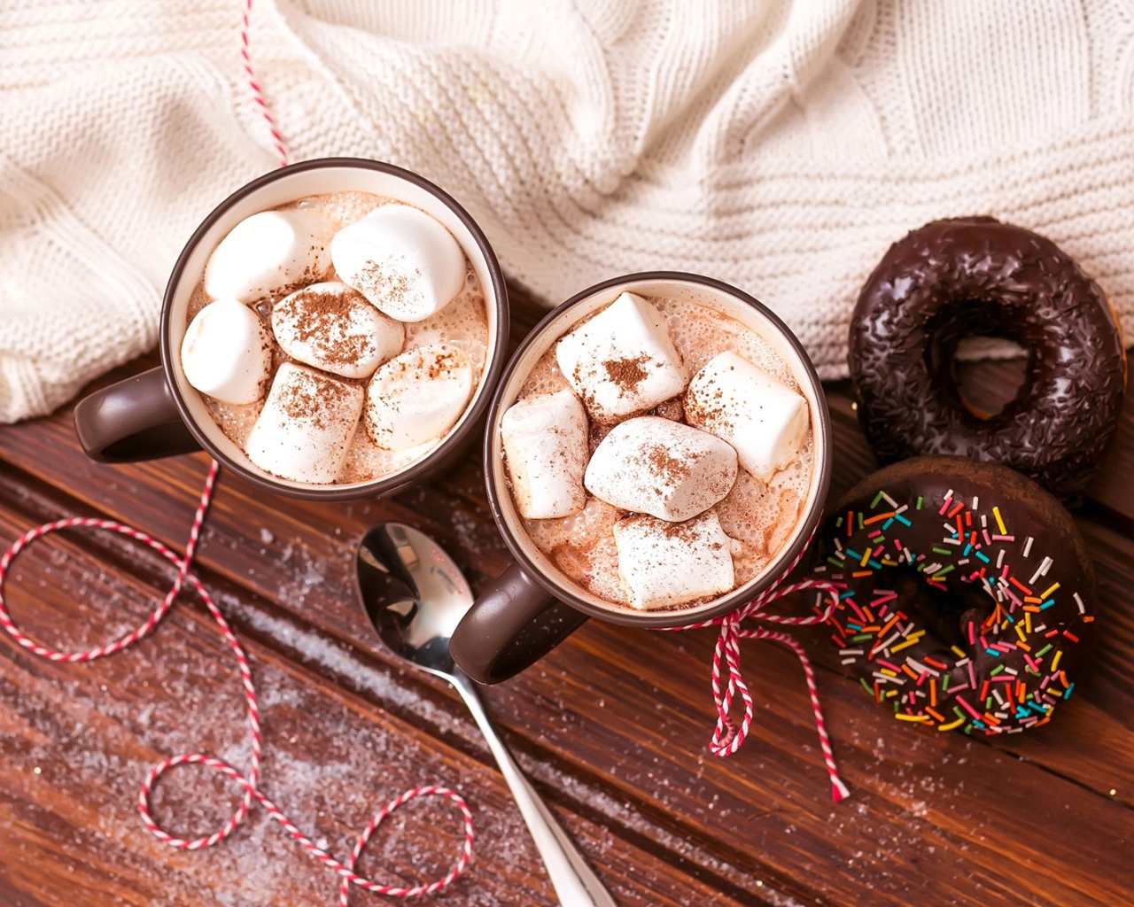 Горячий какао с маршмеллоу с пончиками на столе 