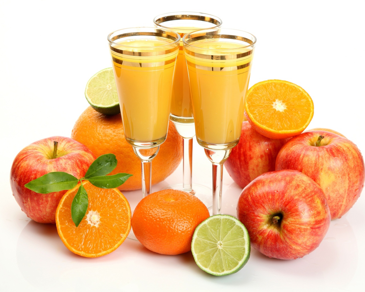 Сок в фужерах на столе с яблоками и мандаринами 