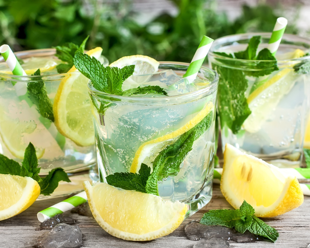 Лимонад с мятой и кусочками лимона в стаканах на столе