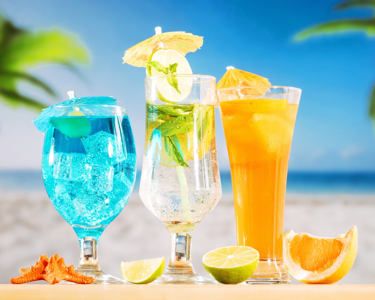 Три вкусных тропических коктейля стоят на пляже
