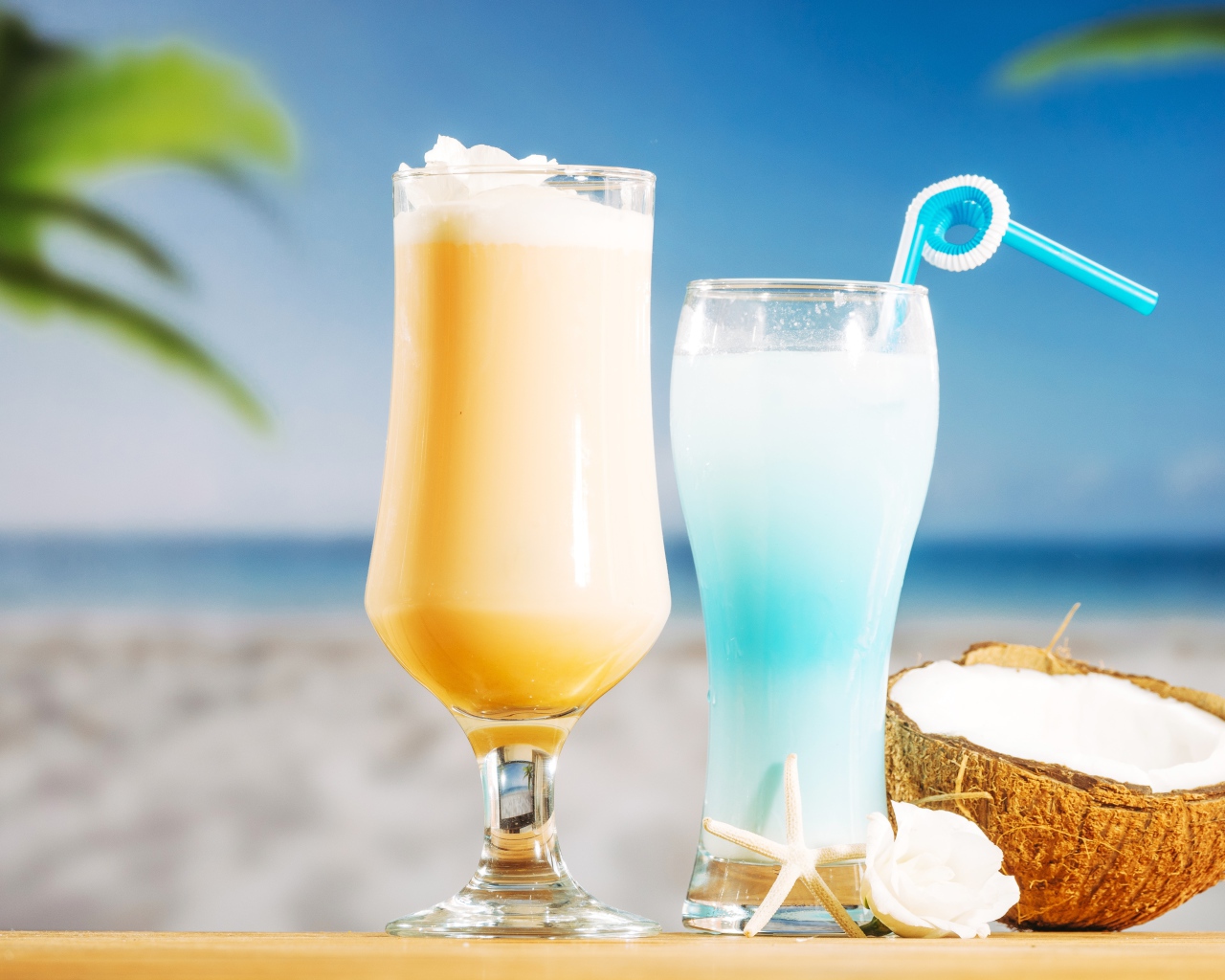 Два коктейля с кокосом на столе на тропическом пляже