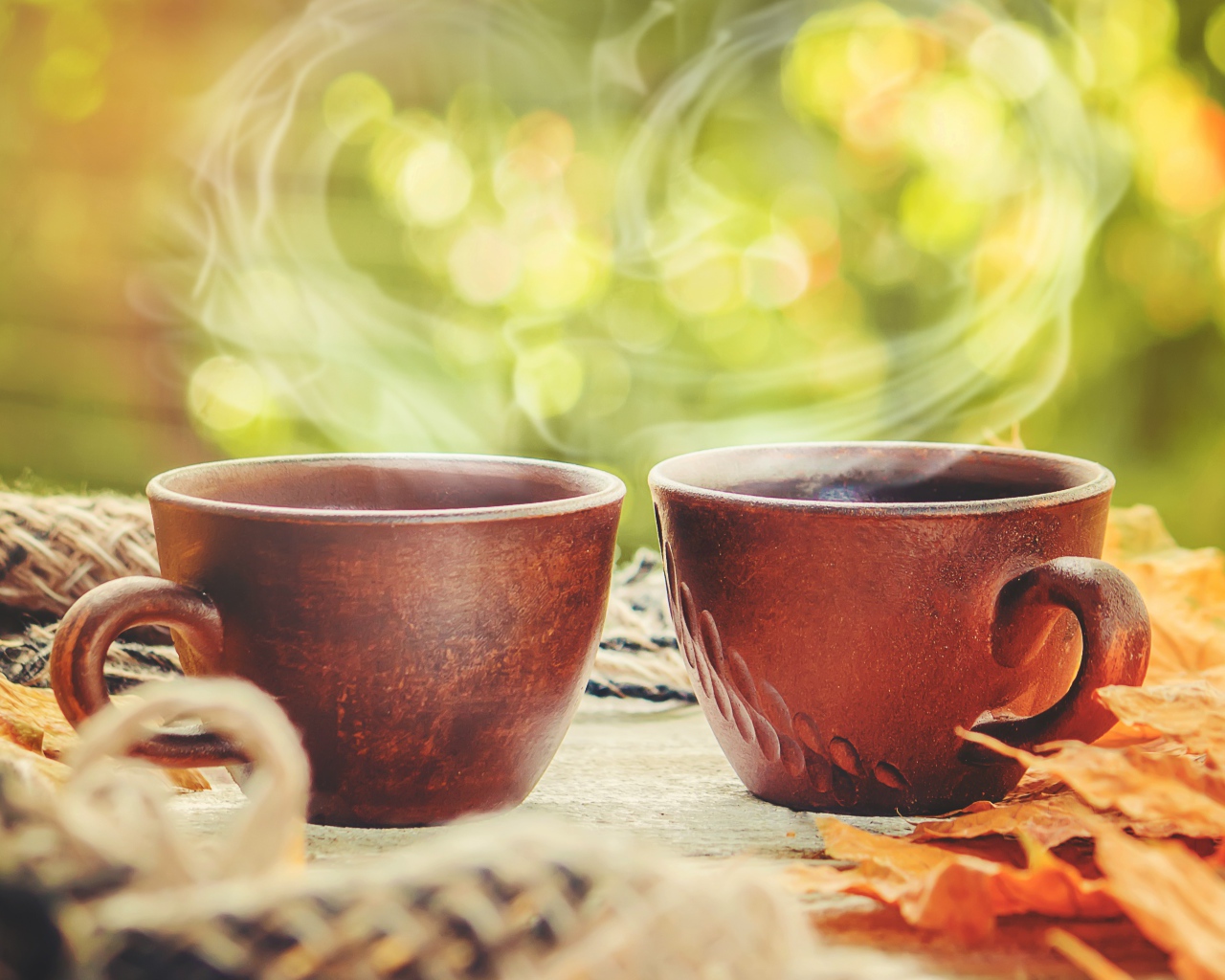 Два чашки горячего кофе с паром на столе осенью 