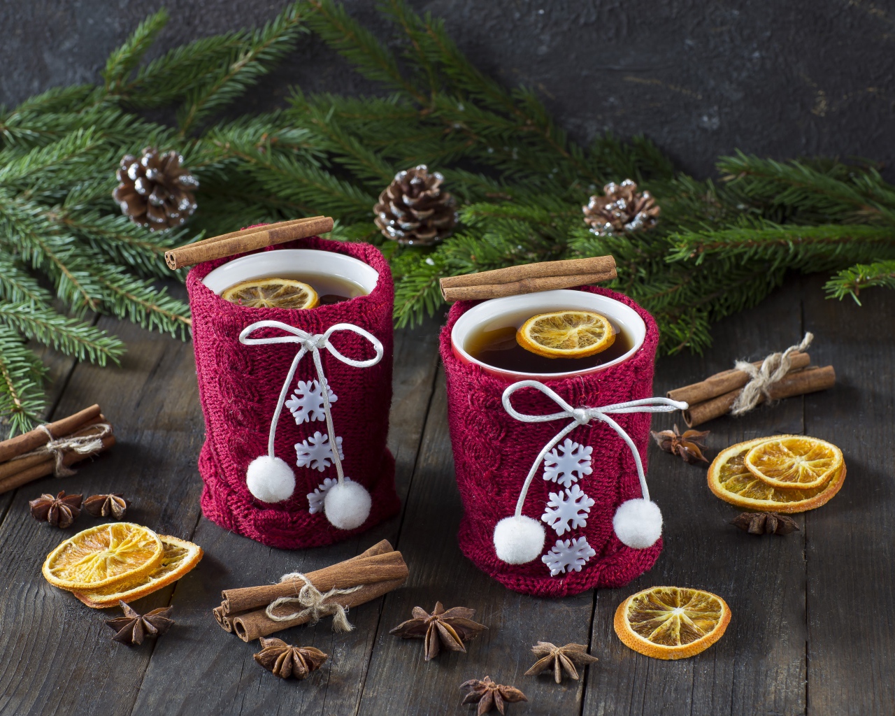 Две чашки горячего чая с лимоном на столе с еловыми ветками