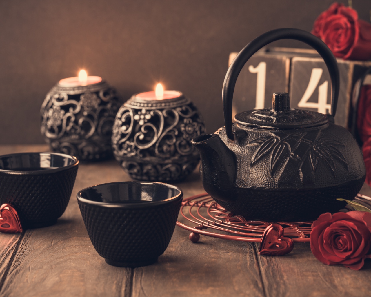 Две чашки чая на столе со свечами и красными розами