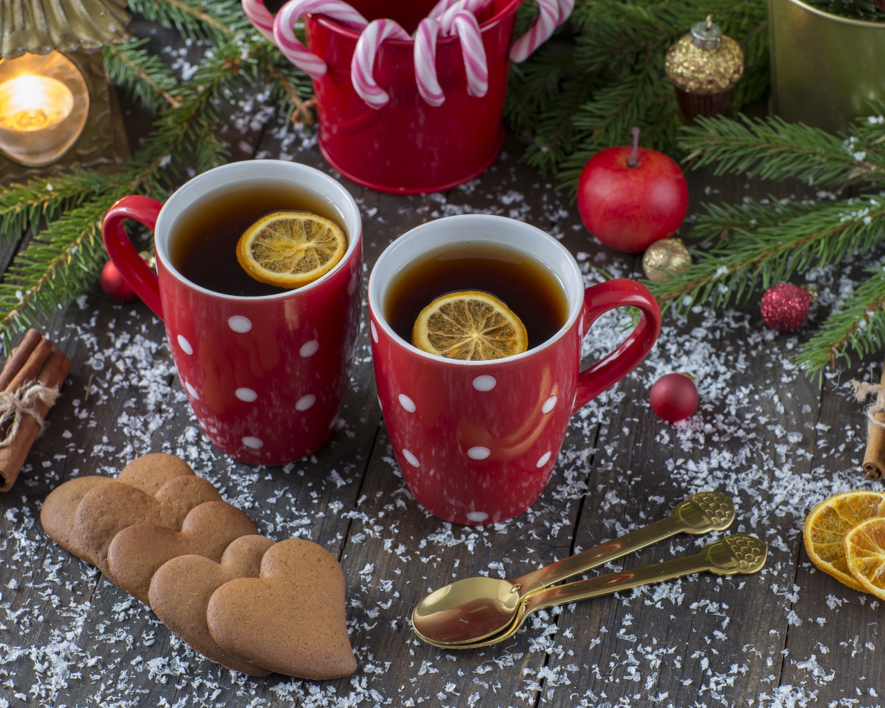 Две чашки чая с лимоном на столе с печеньем и еловыми ветками