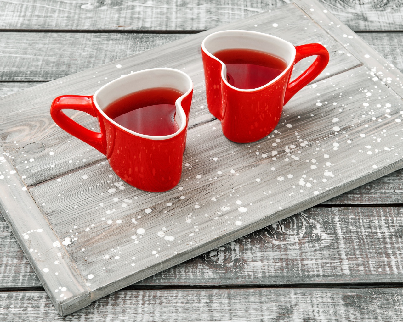 Две красные чашки в форме сердца на столе 