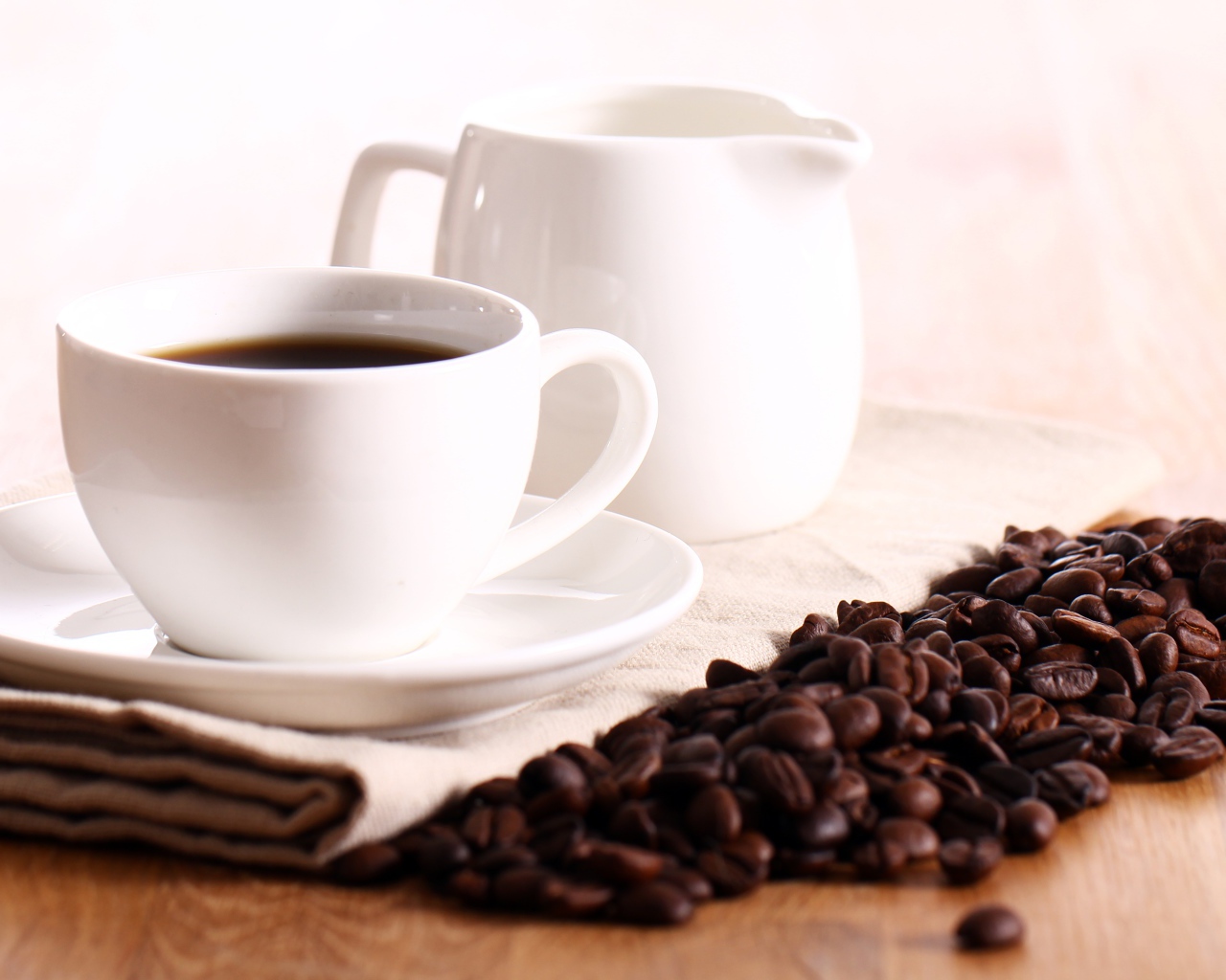 Белая чашка кофе на столе с молоком и зернами