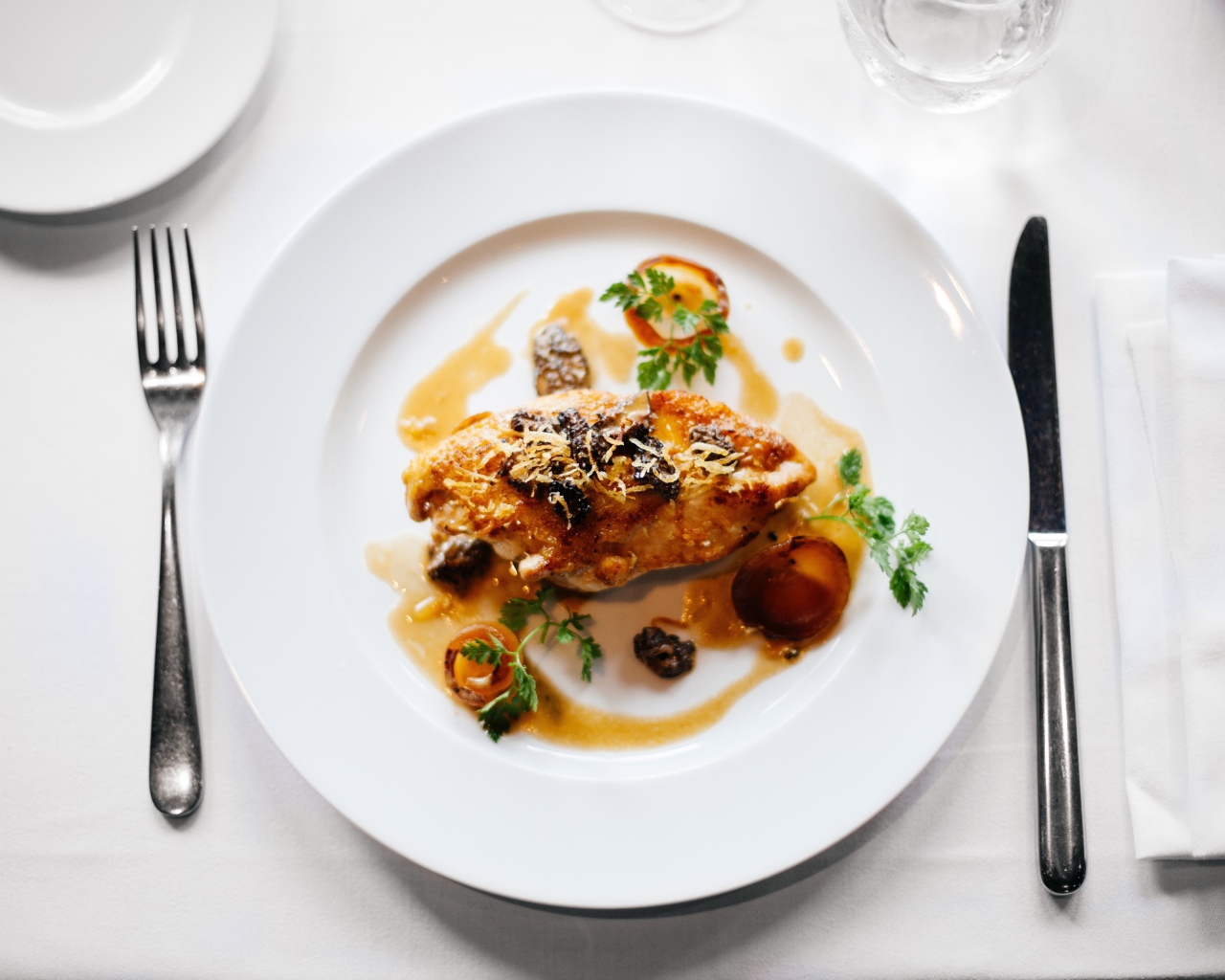 Кусок жареного мяса на большой белой тарелке 