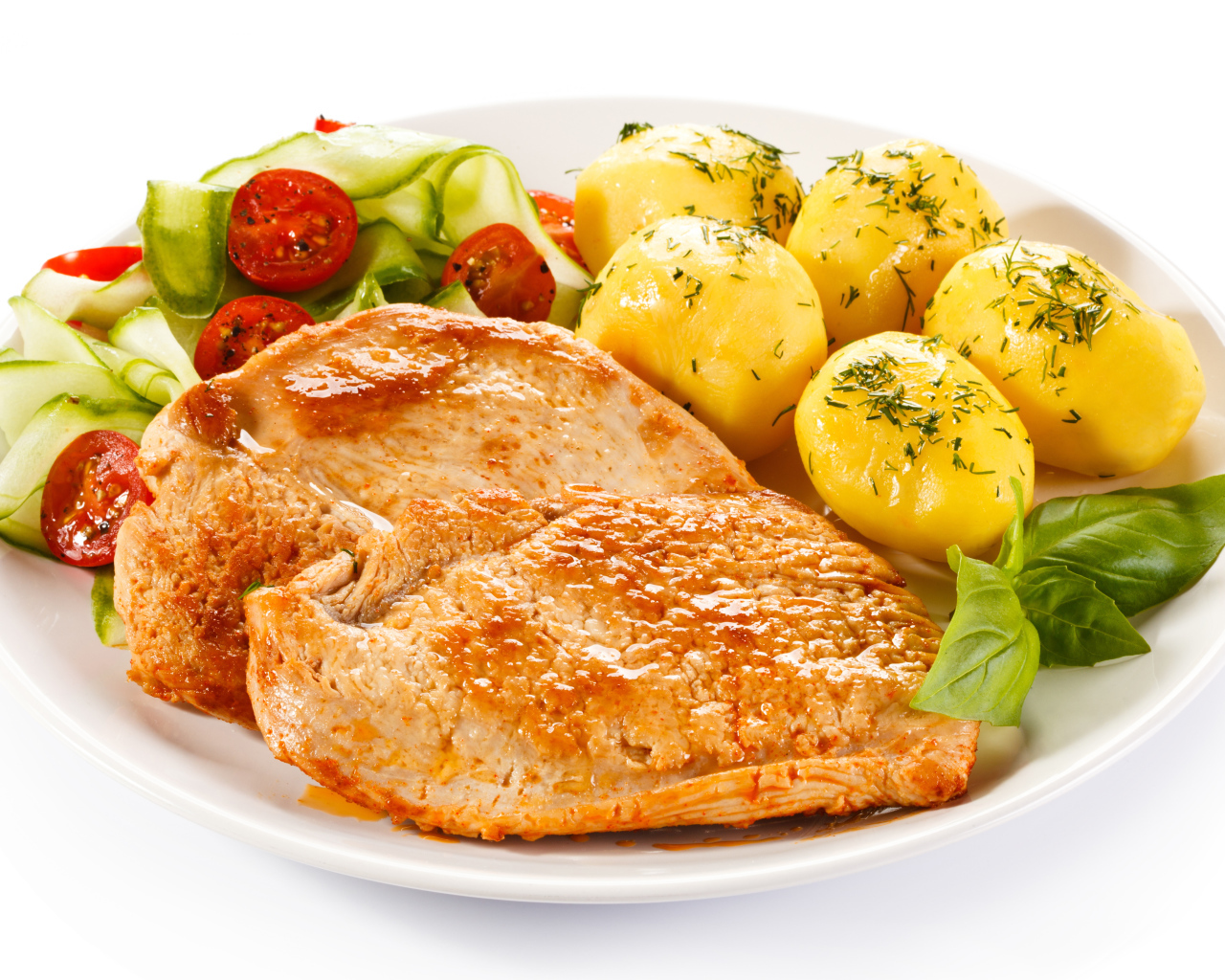 Кусок сочного куриного мяса на тарелке с картофелем и салатом