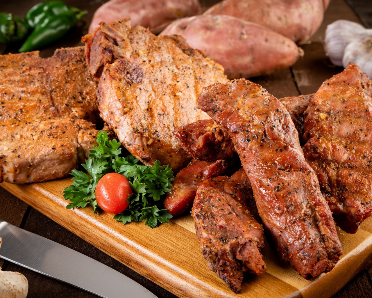 Аппетитное запеченное мясо на столе с чесноком и картофелем