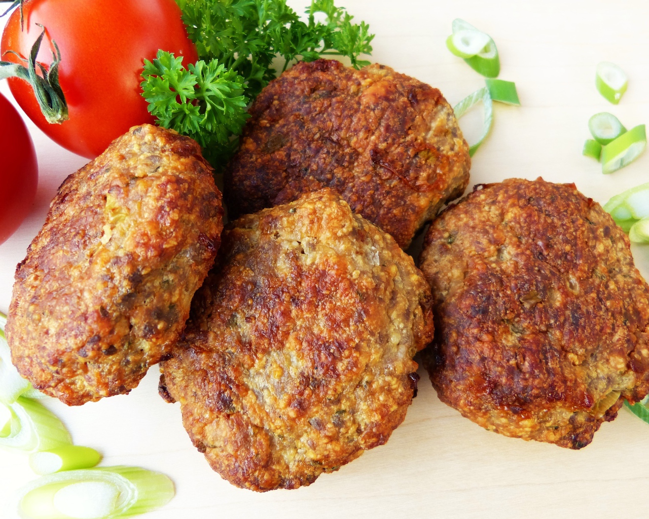 Аппетитные котлеты на тарелке с помидорами и петрушкой