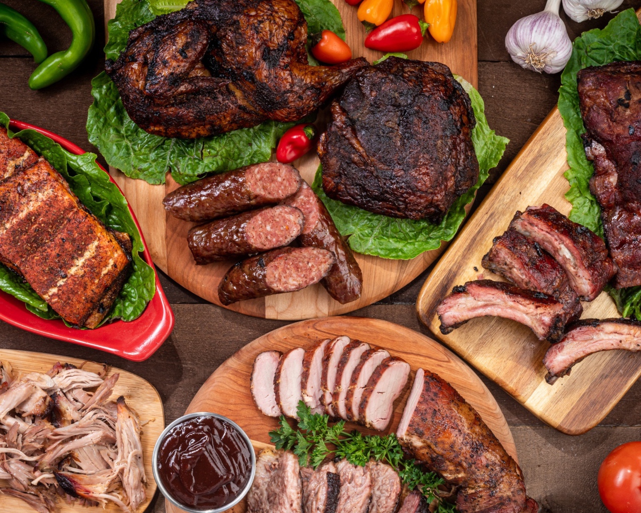 Вкусные запеченные мясные продукты на столе с овощами 