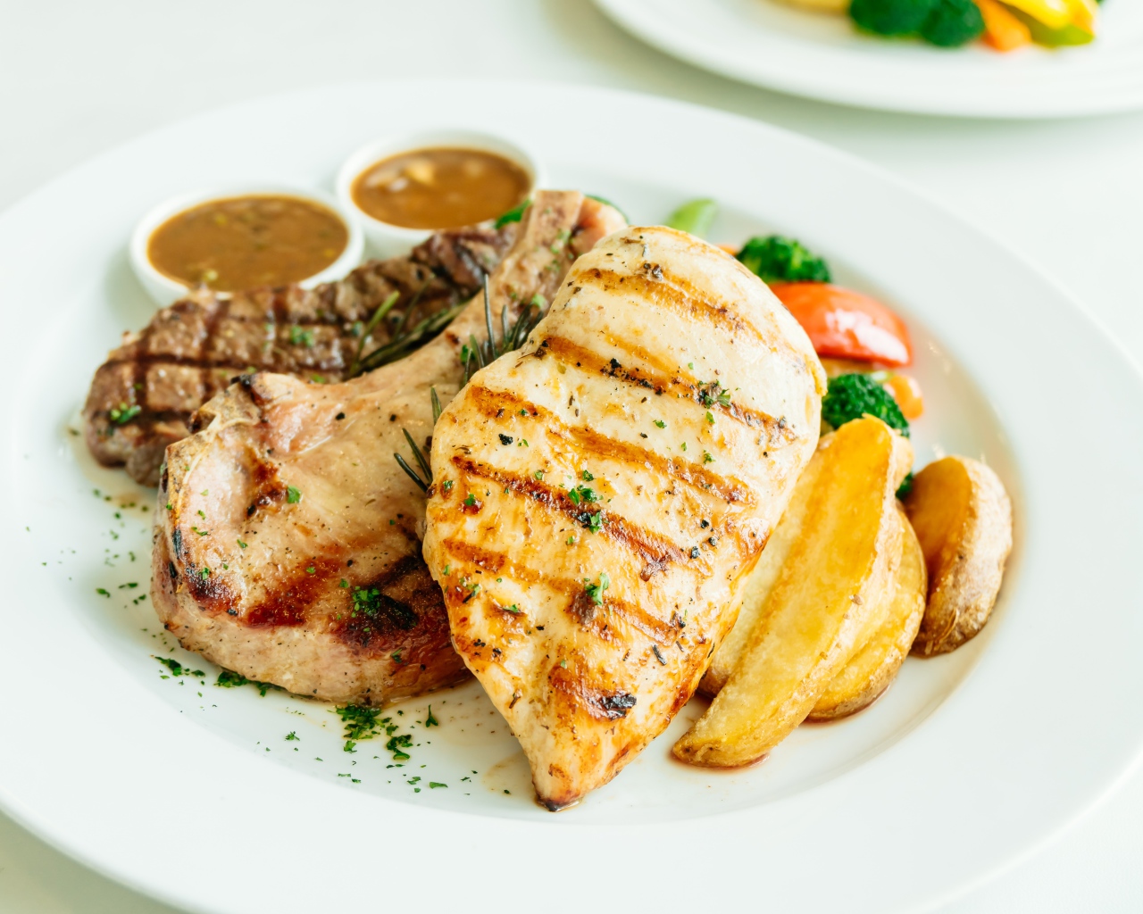 Запеченное мясо гриль на тарелке с овощами