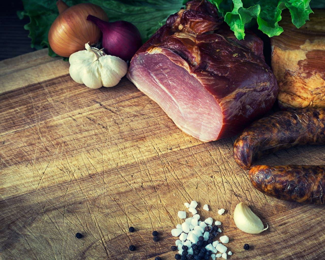 Мясные продукты на столе со специями, луком и чесноком 