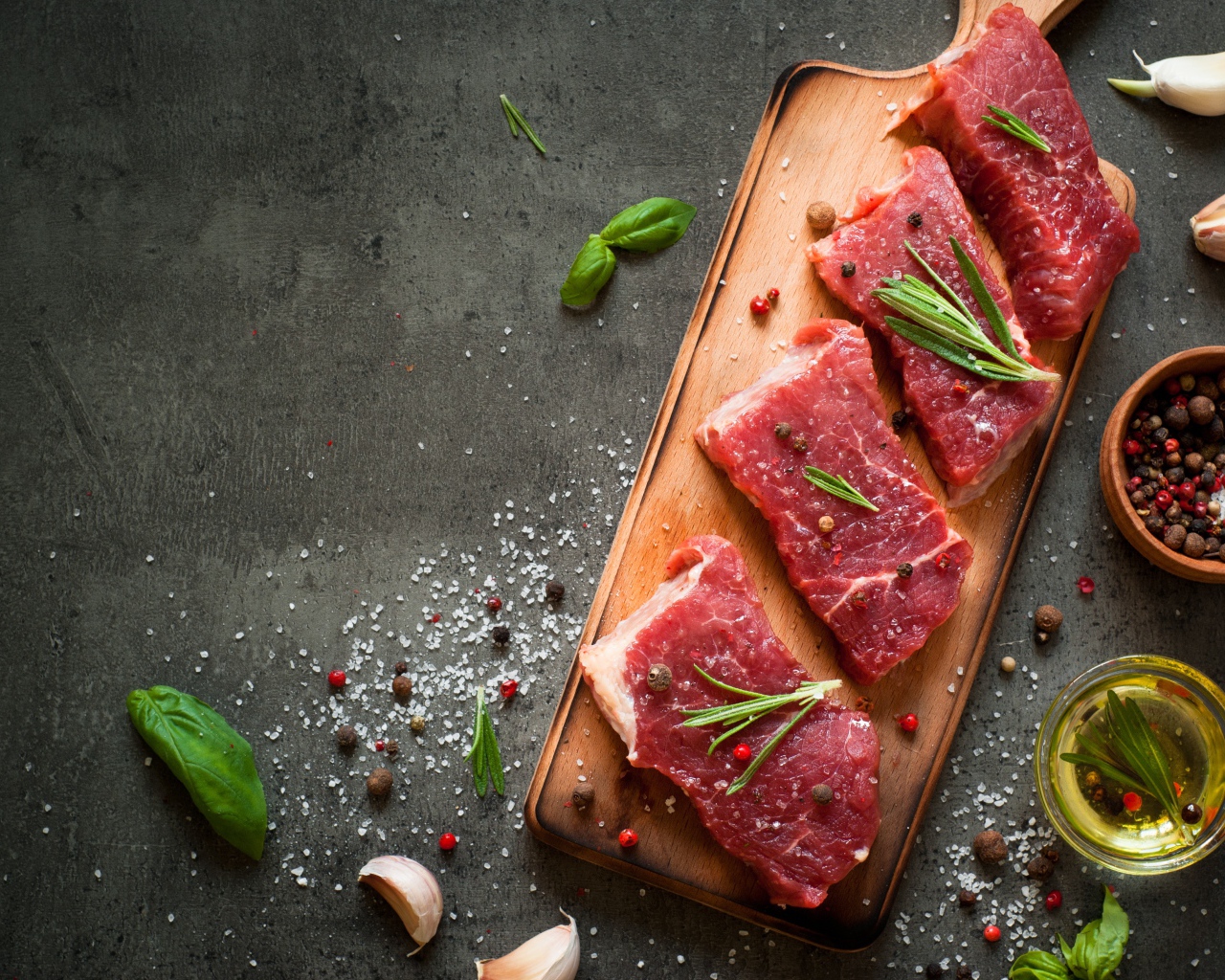 Куски мяса со специями и зеленью на доске 