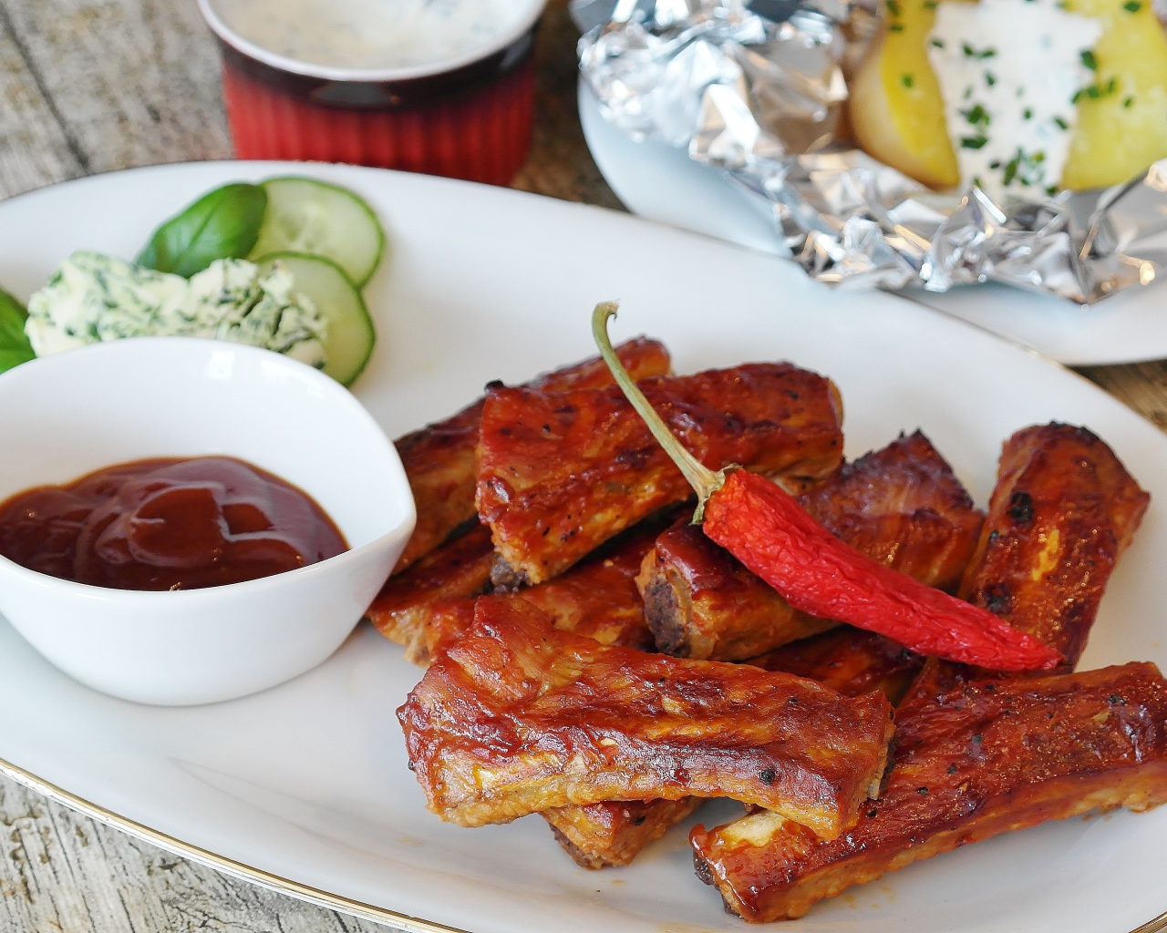 Ребрышки на тарелке с соусом и острым перцем