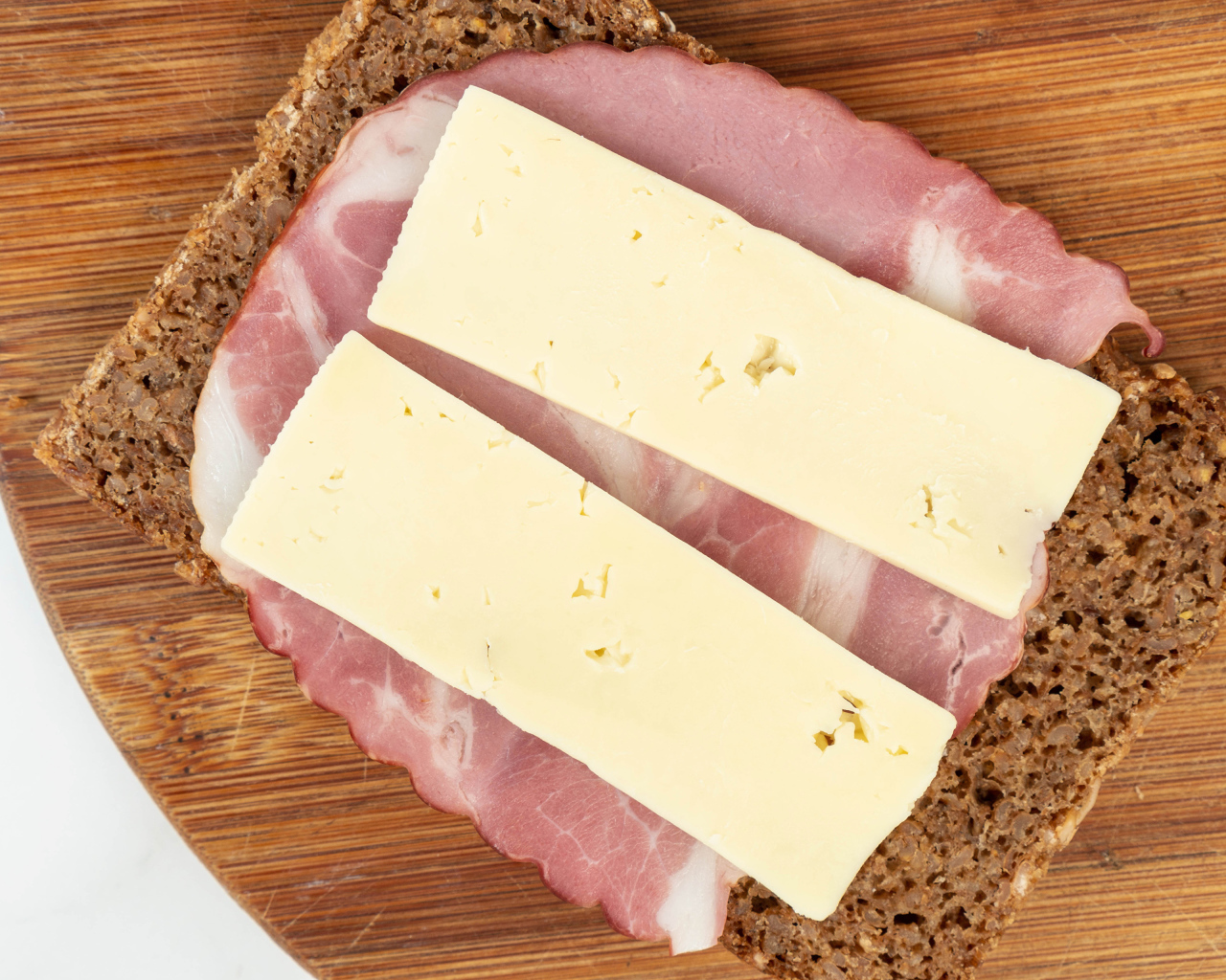 Бутерброд с ветчиной и сыром на доске 