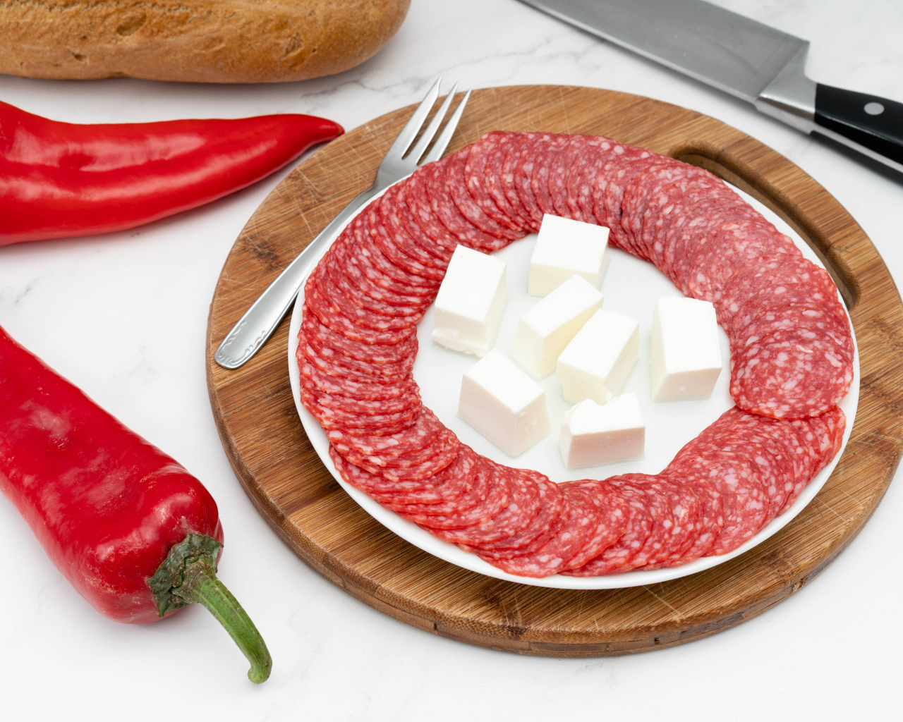 Колбаса с сыром на столе с красным сладким перцем