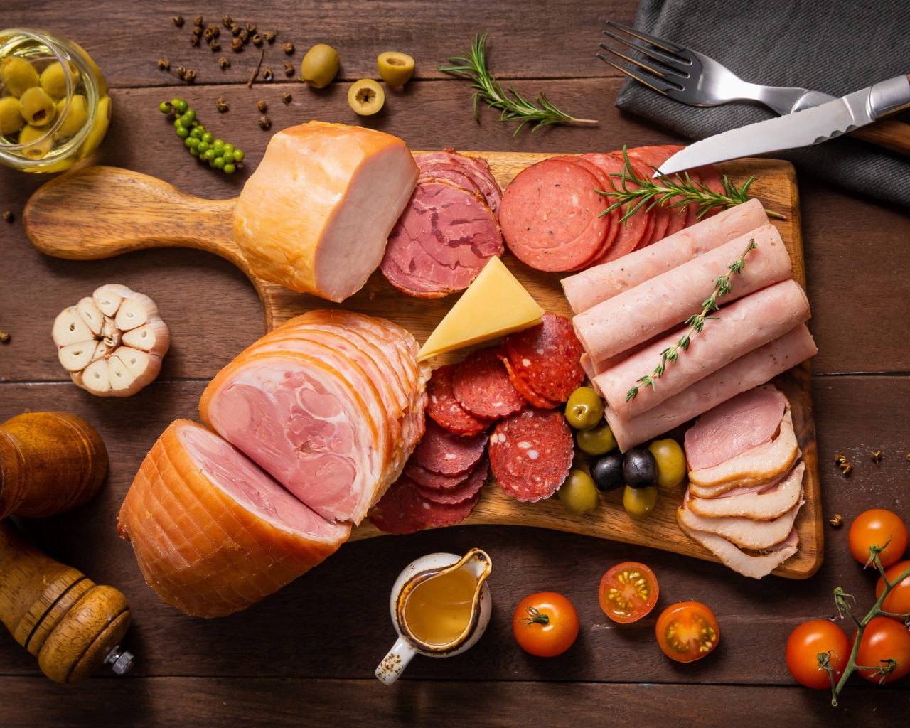 Колбасы и мясные продукты на доске со специями