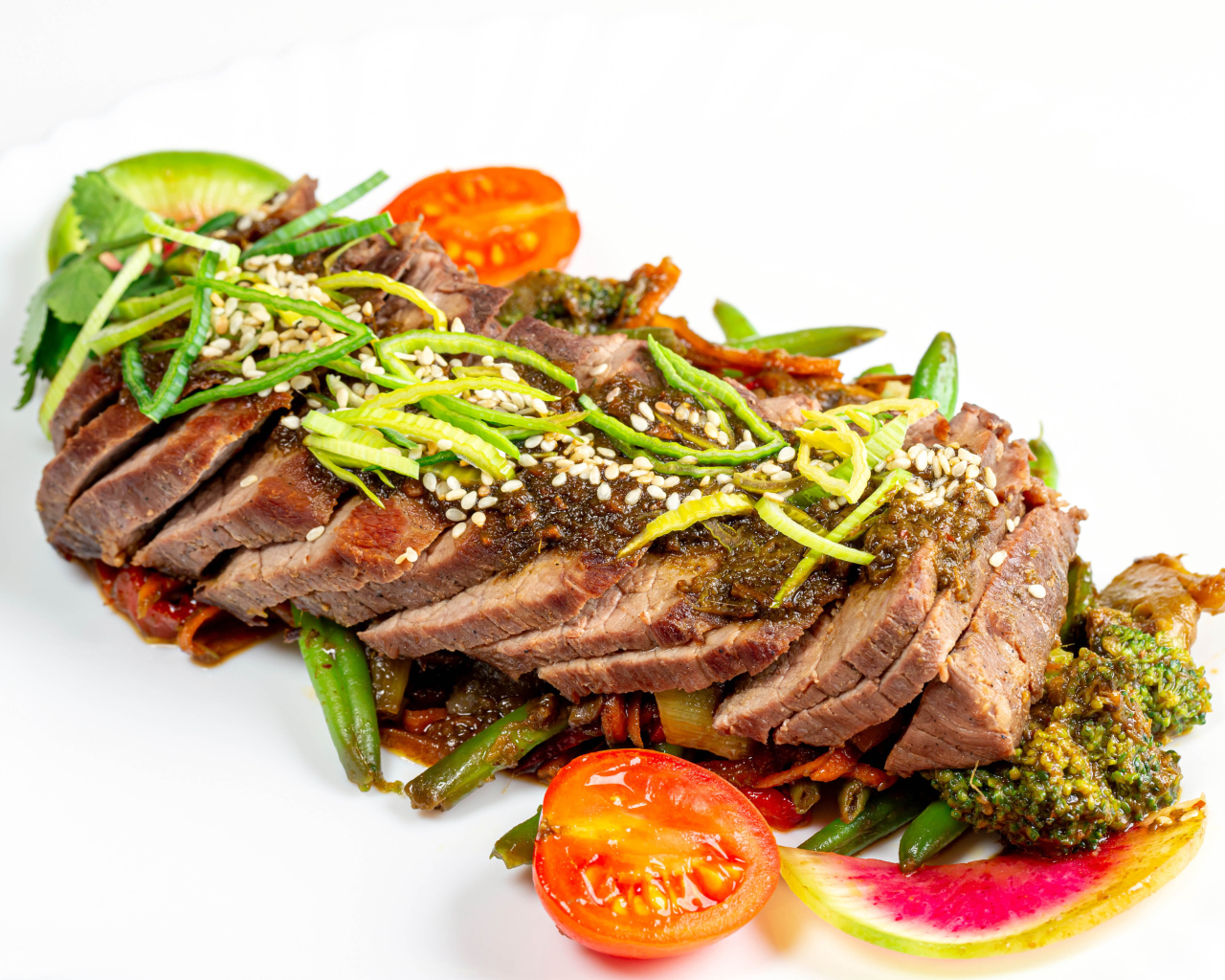 Мясо нарезанное кусочками на белом фоне с овощами