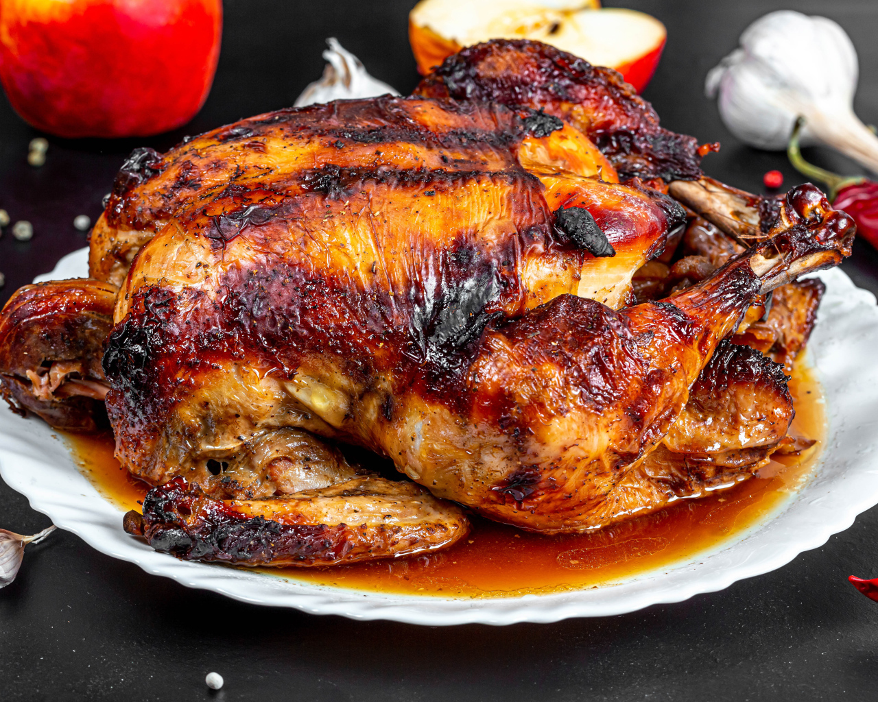 Вкусная запеченная курица на белой тарелке на столе с овощами