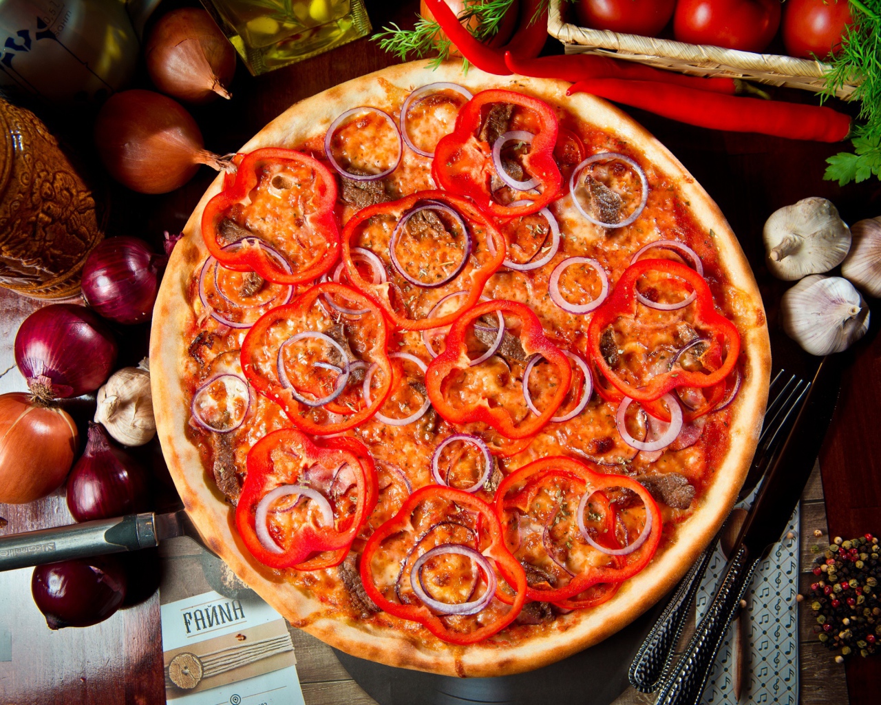 Большая пицца с мясом, луком и болгарским перцем на столе 