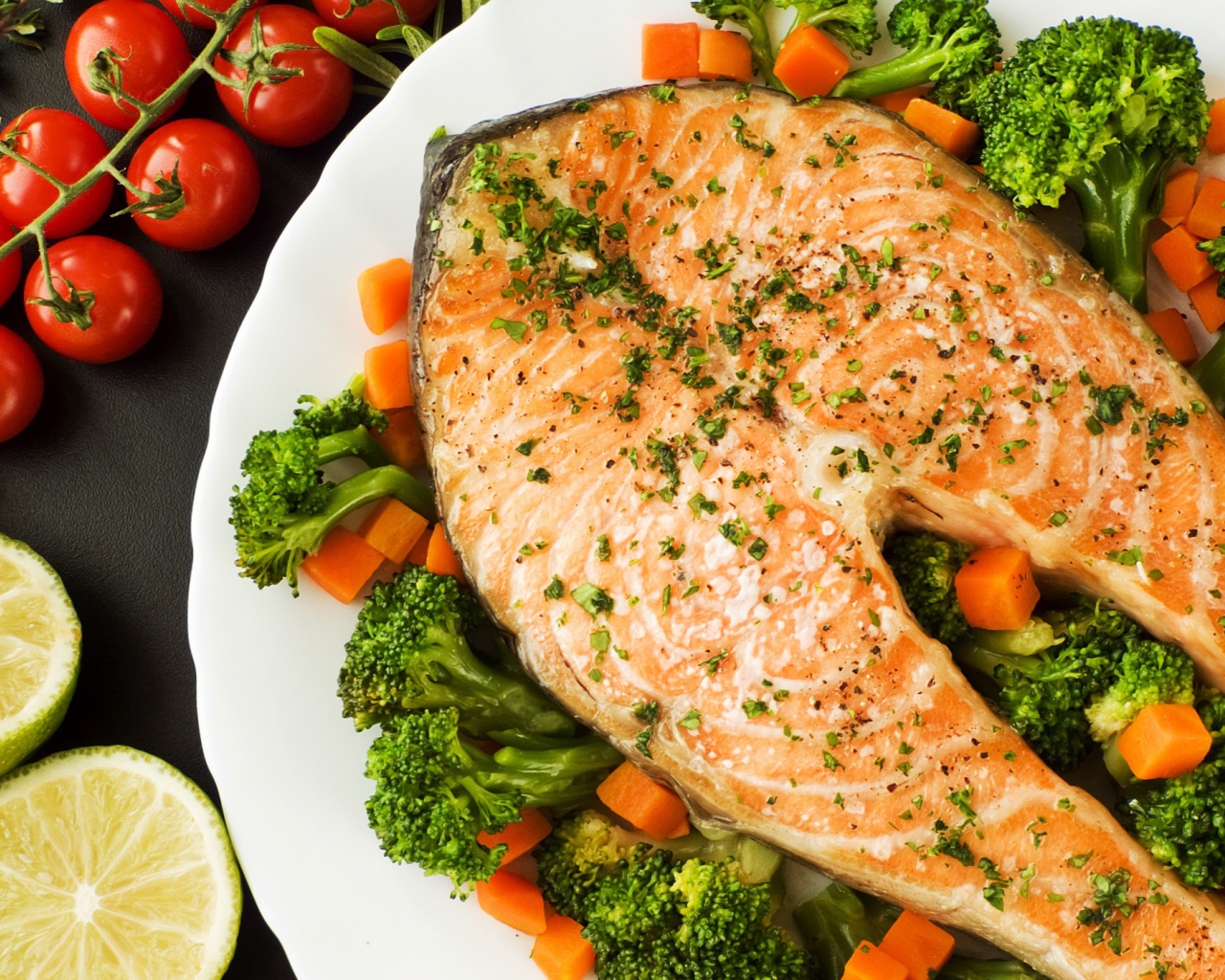 Кусок красной рыбы на тарелке с морковью и брокколи 