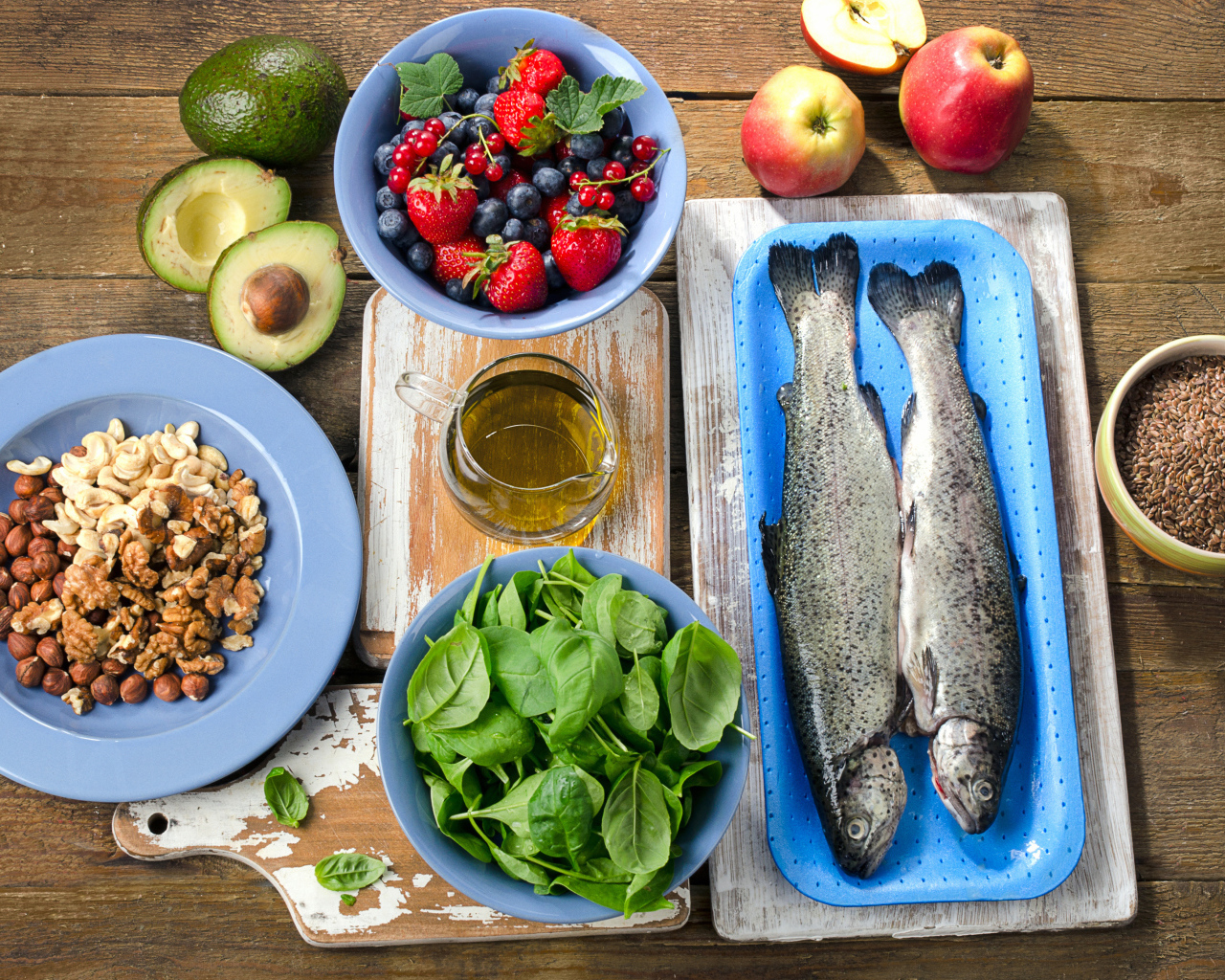 Fresh fish on a table with nuts, basil and berries