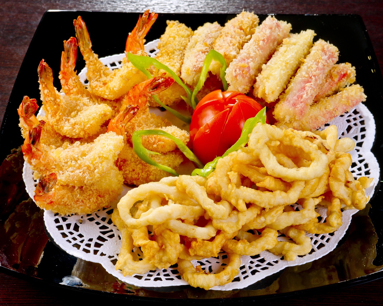 Морепродукты в кляре на тарелке с помидором