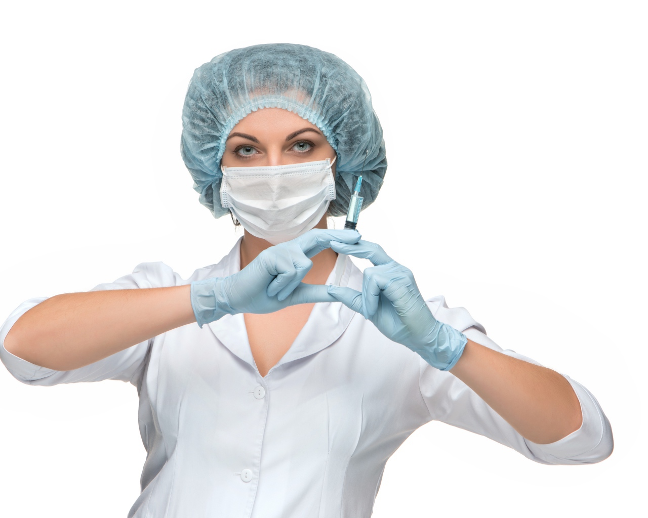 Девушка медсестра в маске со шприцем в руках на белом фоне