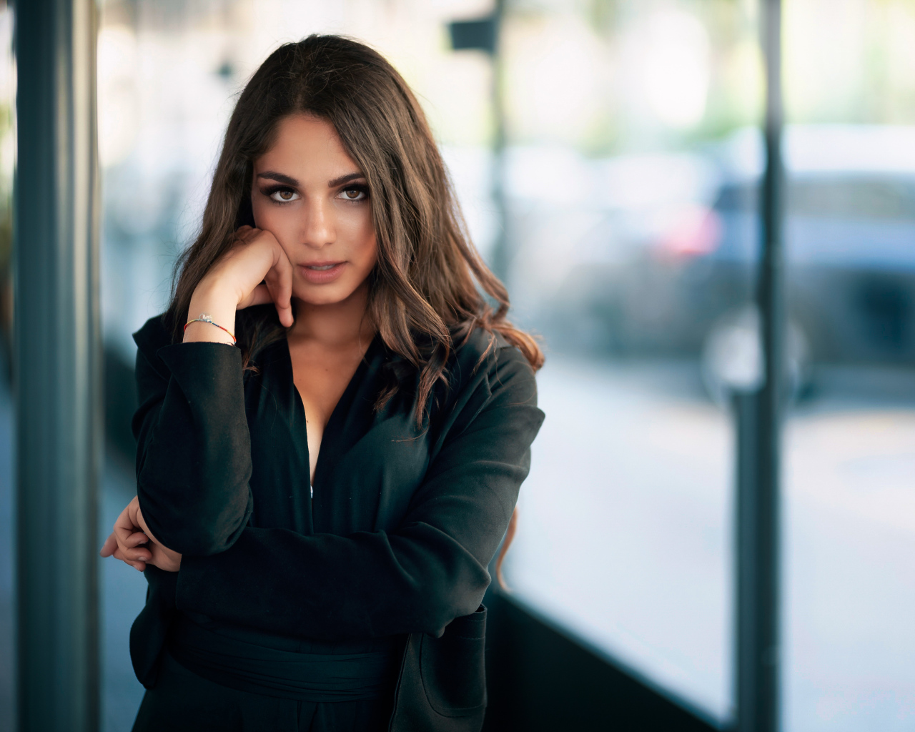 Милая девушка в черном наряде стоит на остановке