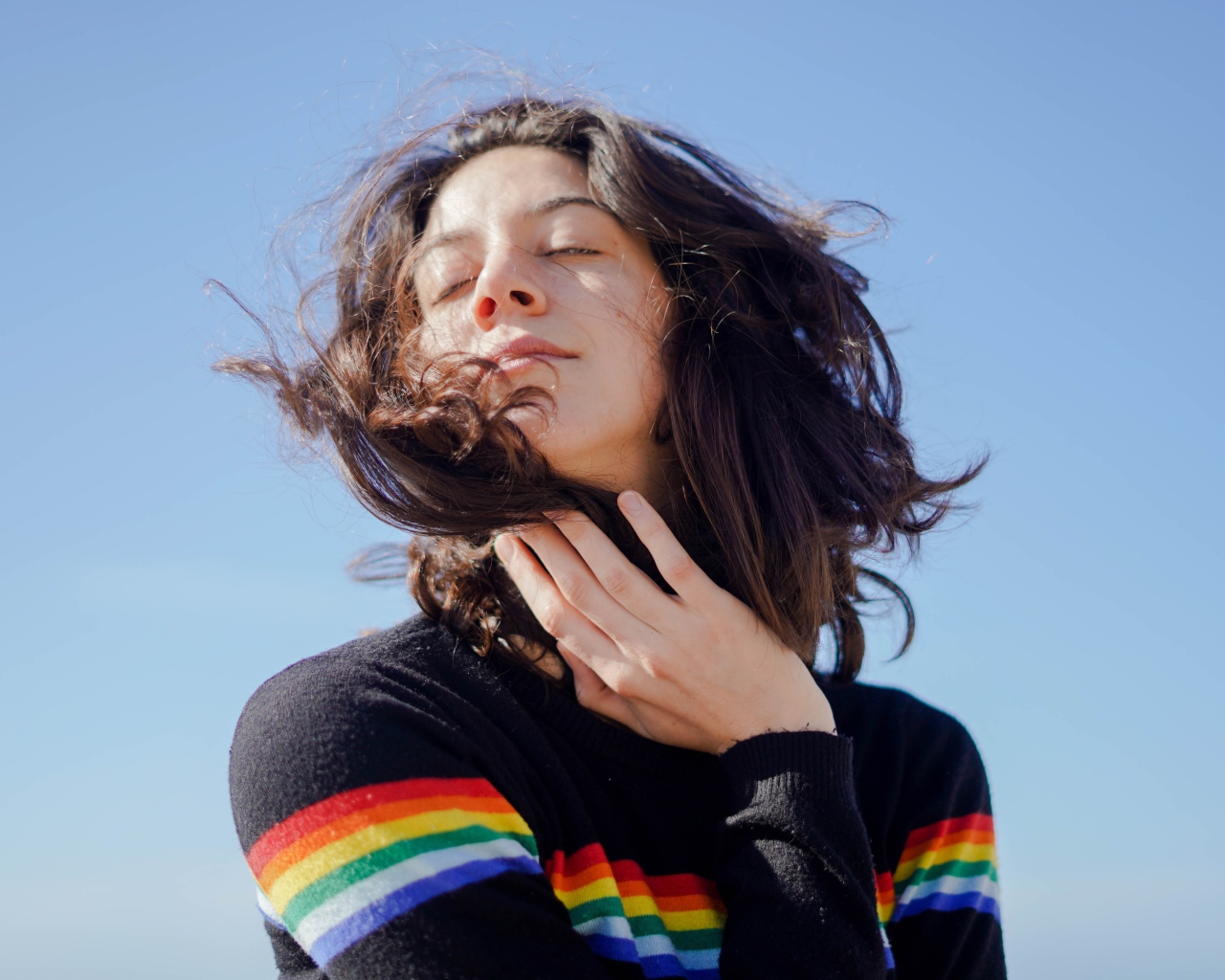 Молодая девушка греет лицо на солнце