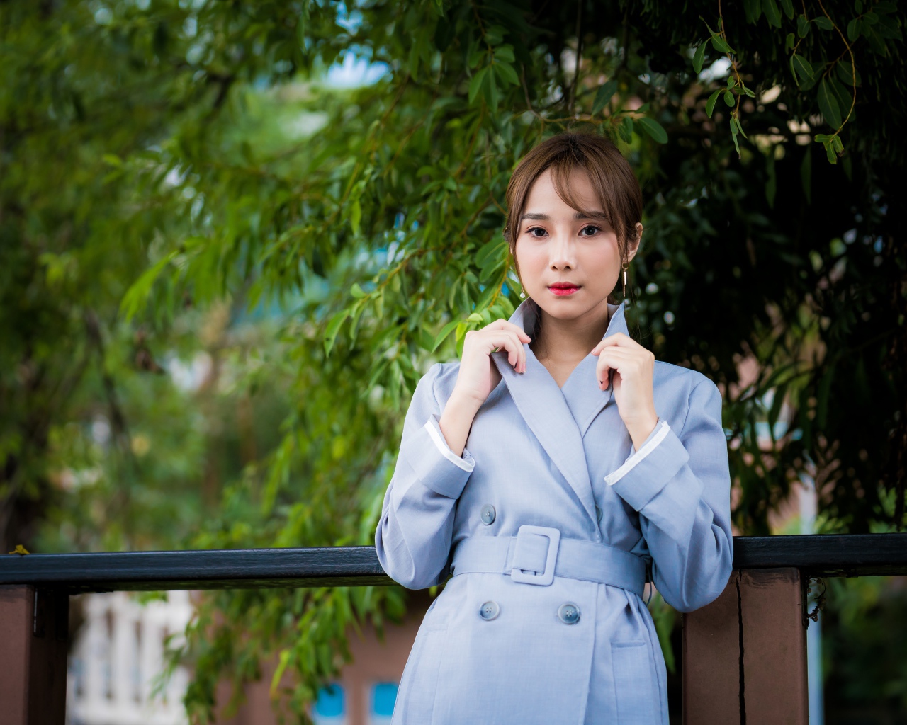 Девушка азиатка в голубом пальто в парке