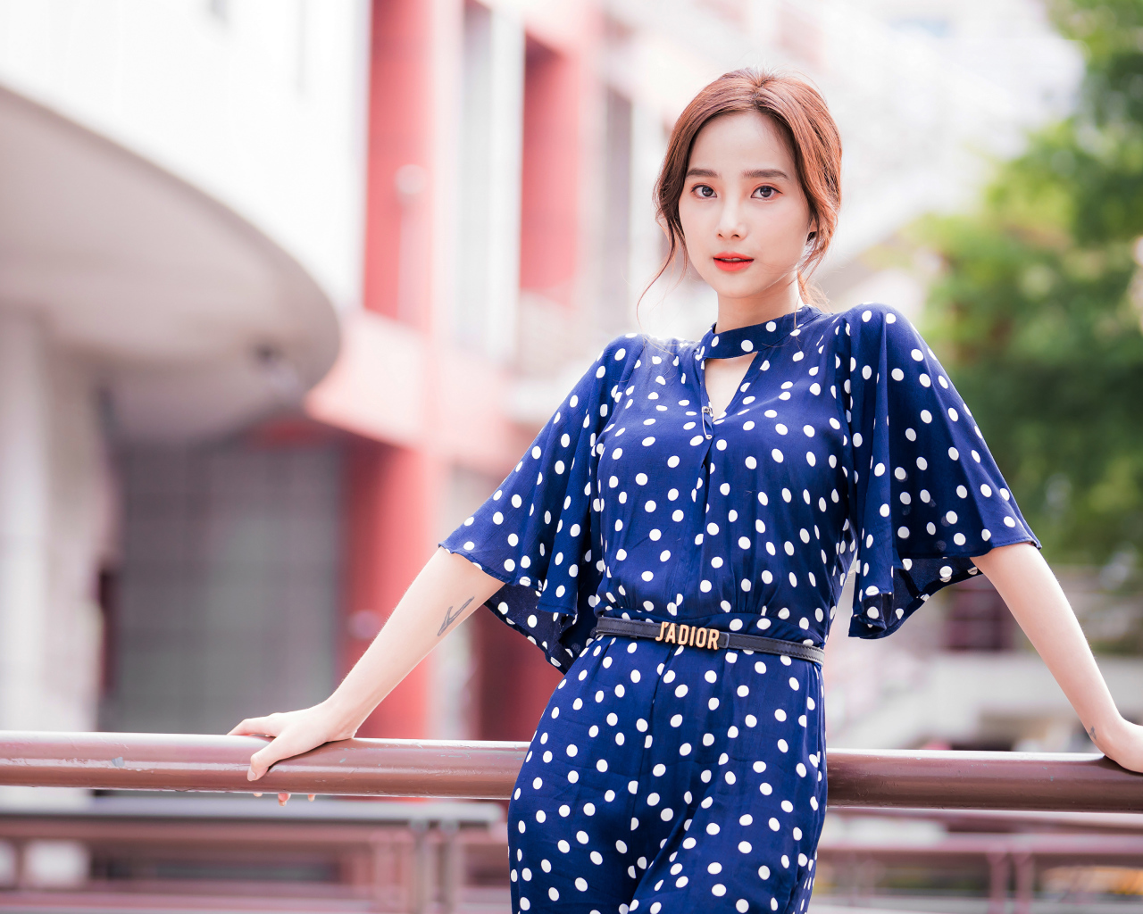 Девушка азиатка в синем платье в белый горошек