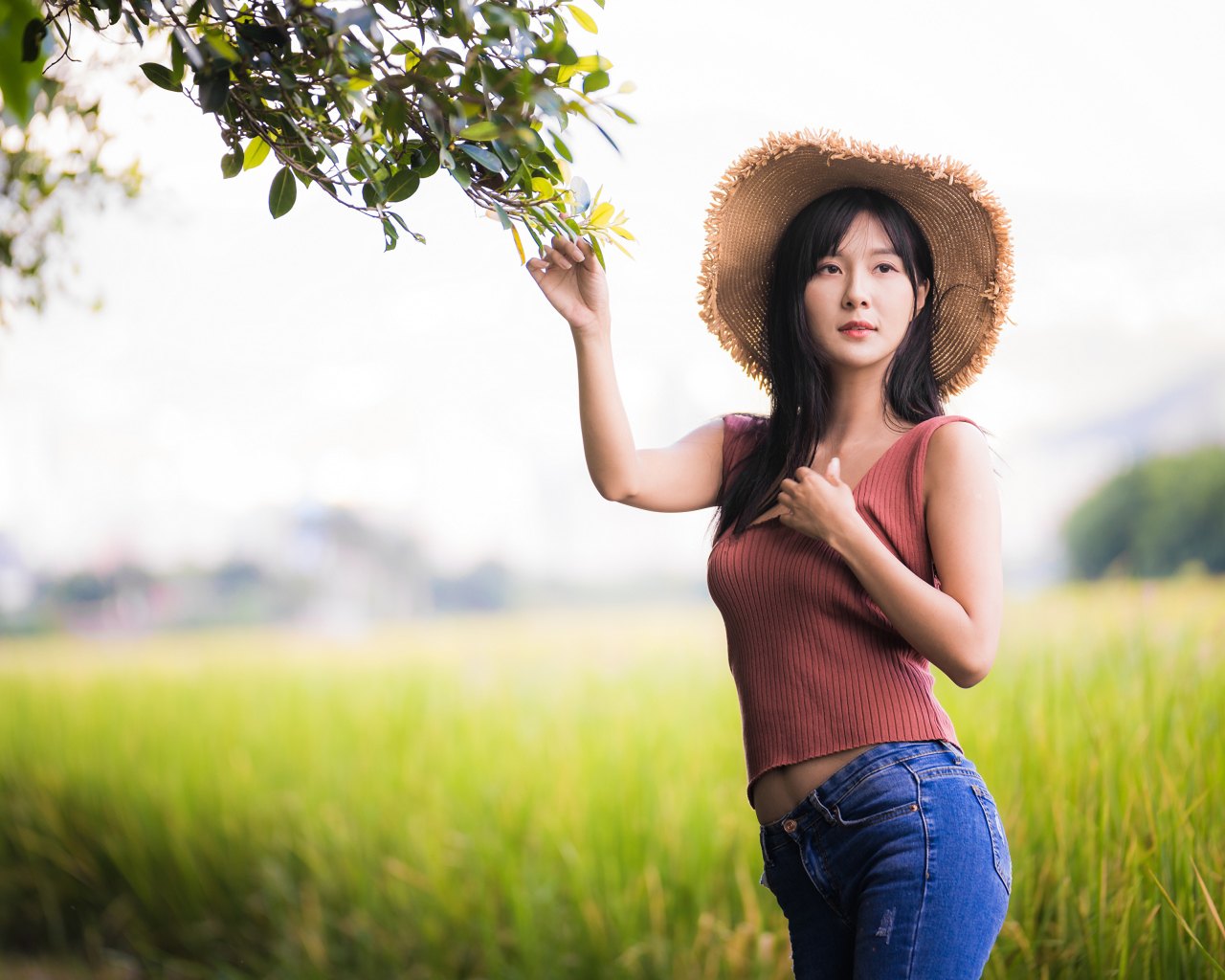 Девушка азиатка в шляпе на поле 