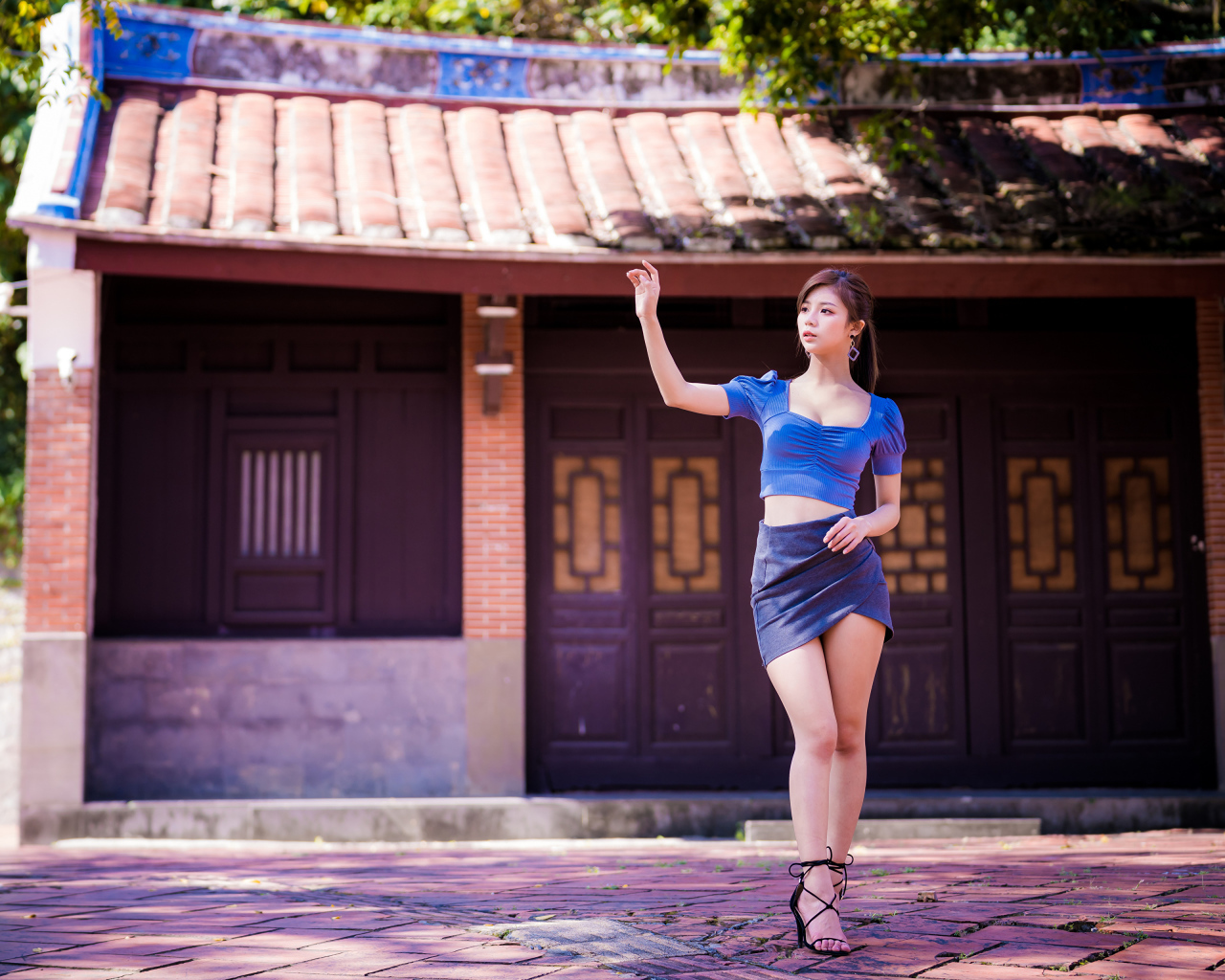 Девушка азиатка в короткой юбке у здания 