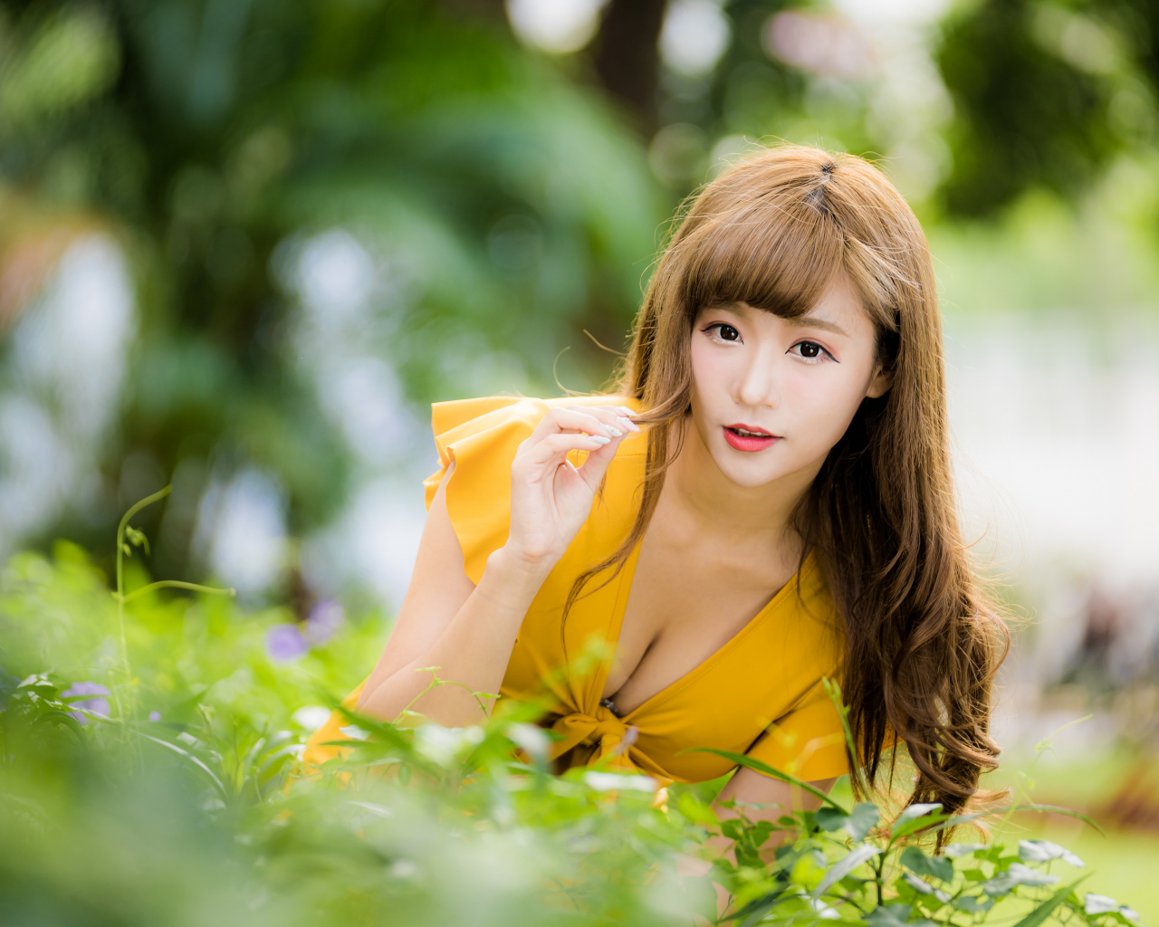 Девушка азиатка в желтом платье в парке 
