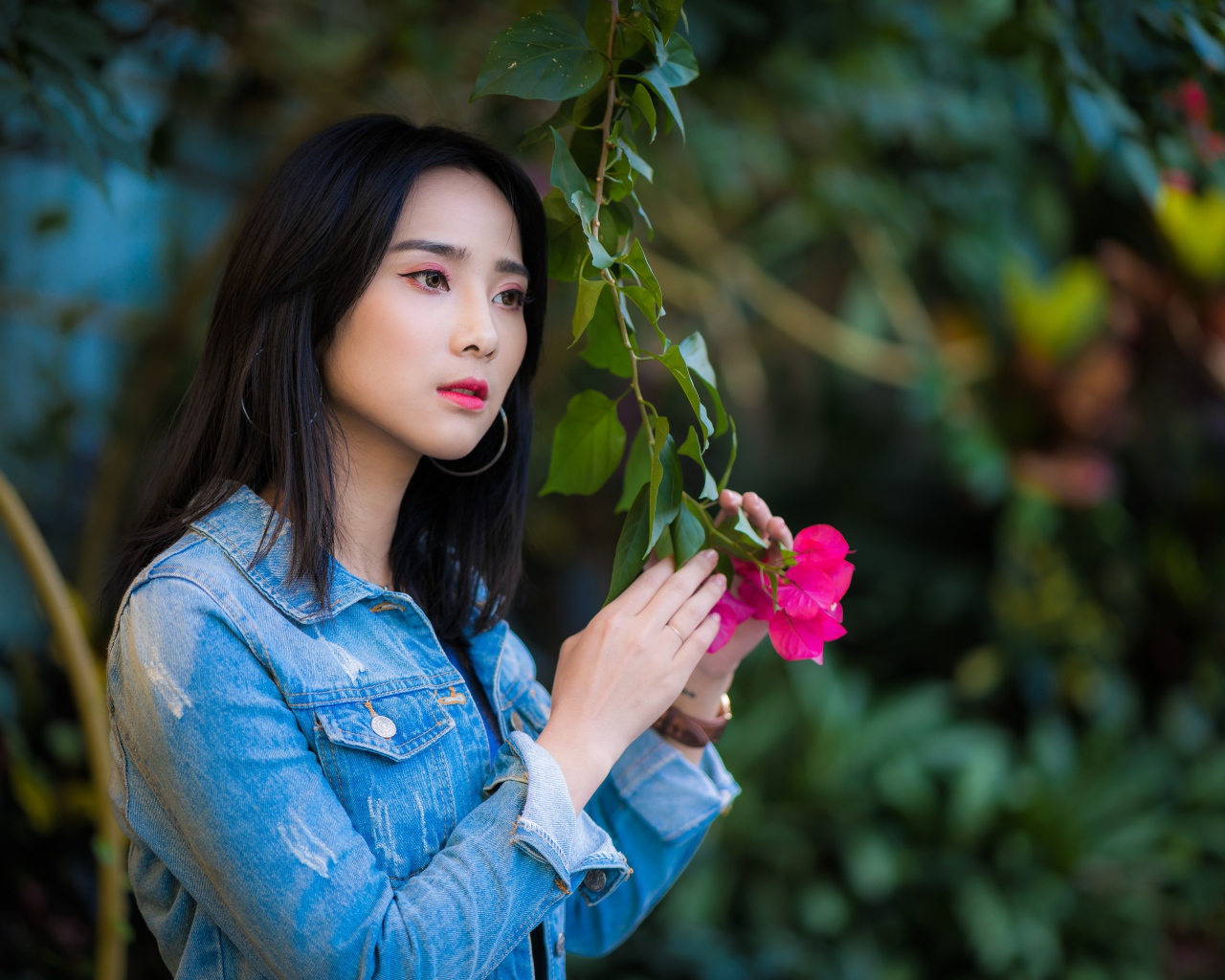 Девушка азиатка в джинсовой куртке в парке