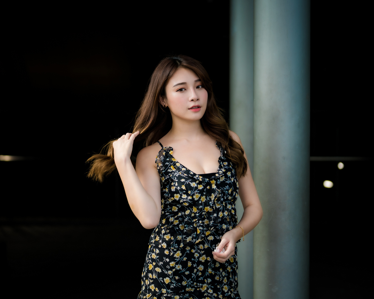 Девушка азиатка в платье трогает волосы 