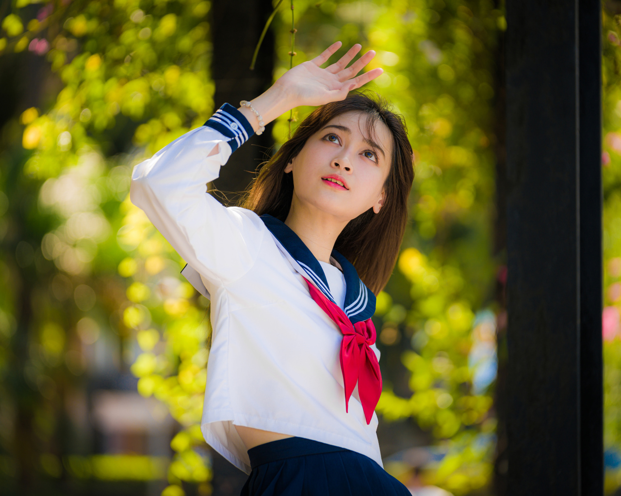 Девушка азиатка в форме с красным галстуком