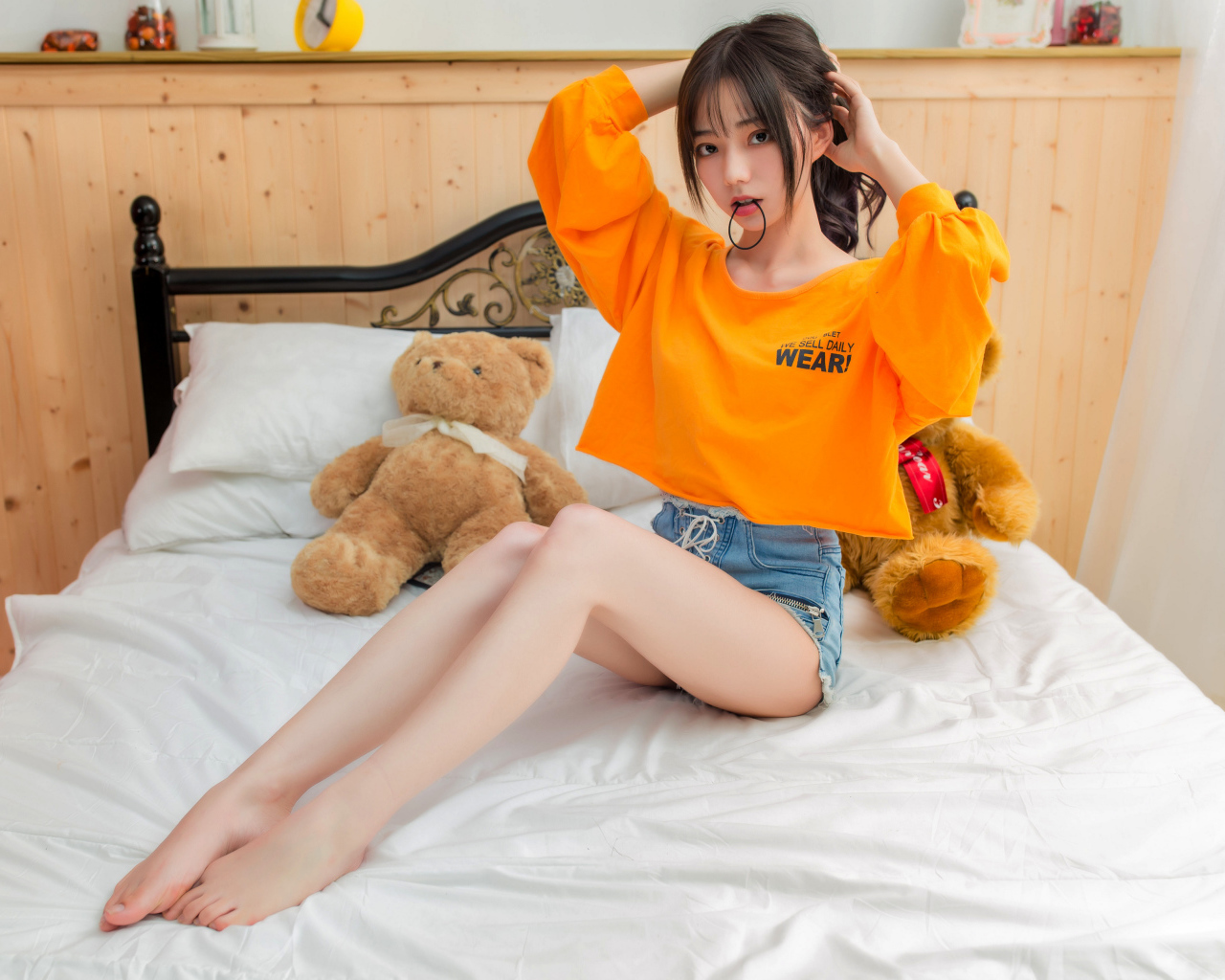 Девушка азиатка на кровати с игрушками