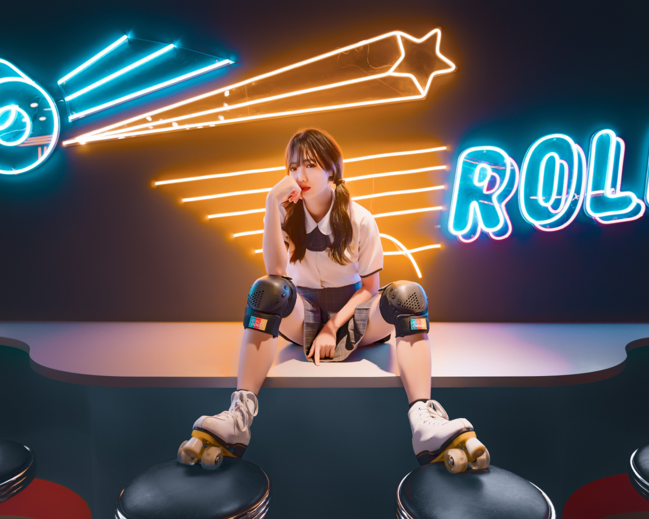 Девушка азиатка сидит в роликах на фоне вывески 