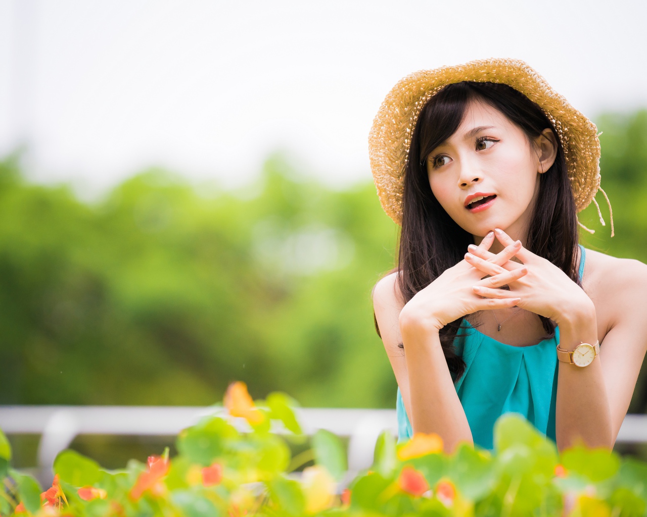 Девушка азиатка с часами на руке в шляпе