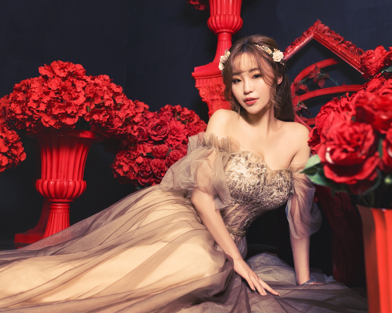 Азиатка в красивом платье в комнате с красными цветами